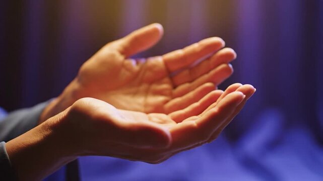 Gently cupped hands in warm light against a soft purple bokeh background
