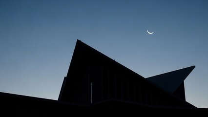 Silhouette of Modern Architecture Under Crescent Moon in Evening Sky.