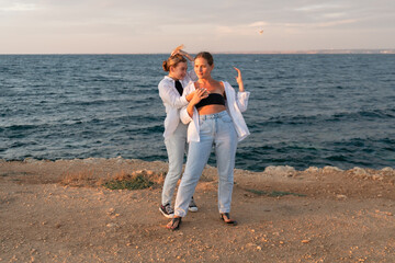 Friends Beach Sunset - Two women pose on a beach at sunset.