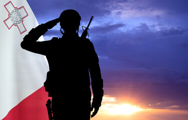 Silhouette of a soldier with Malta flag against the sunset. National Holidays concept. Armed Force of Malta