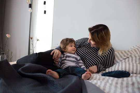 Mother and infant son relaxing in bed