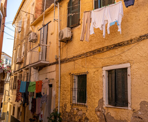 Laundry hangs above the alley in Corfu old town, Greece. Traditional architecture buildings.
