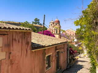Corfu island old town. Monastery of Panagia Tenedos on a cobblestone alley. Church bell Tower, Greece. .