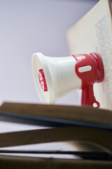 Small megaphone on top of open book.