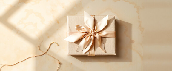 Elegant gift box with ribbon on cream marble background  