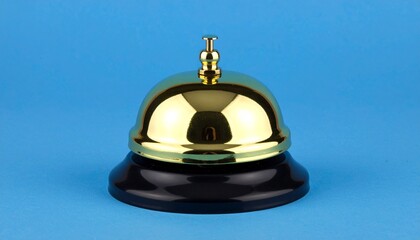 Golden service bell on black base against light blue background, minimalist product photography, glossy metal surface, soft studio lighting, clean composition, sharp focus