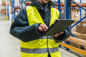 Woman worker using a digital tablet for inventory management and logistics in a low temperature cold storage warehouse