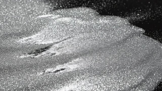 Fine metallic silver sand grains shifting and flowing across a flat surface, creating delicate waves and an intricate granular abstract texture sophisticated, fine metallic silver sand, movement