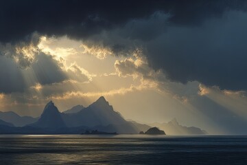 Dramatic sunbeams pierce stormy skies over distant, silhouetted mountains