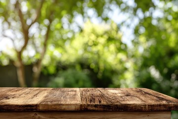 Weathered wooden tabletop in soft focus green foliage background