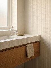 Fototapeta premium Minimalist bathroom sink with white mosaic tiles, wooden vanity, soap dispenser, and towel