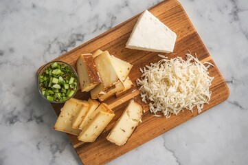 A cutting board with slices of different vegan cheeses