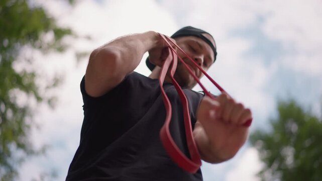 Athlete Exercises Outdoors, Man With Resistance Band Training, Preparing For Pull Exercise In Park, Male Athlete Performing Controlled Assisted Pull With Resistance Equipment Outside