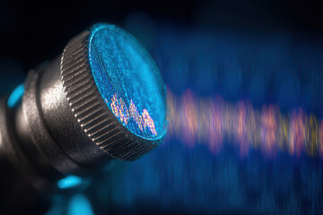 Forensic lab investigation microscope lens with blue light and waveform reflection creating scientific atmosphere and intense focus