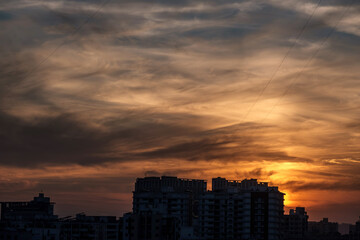 Fototapeta premium Evening scene with lit up and silhouetted buildings against a colourful evening sky at Pune India.