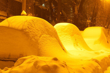 Snow covered cars after snowfall in night city