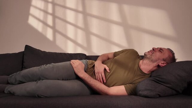 Man with gastritis, chest, stomach and abdominal pain at home.