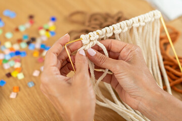 Female hands crafting tapestry using various yarn textures. Captures tactile creativity, slow weaving rhythm, and thoughtful artistic focus.