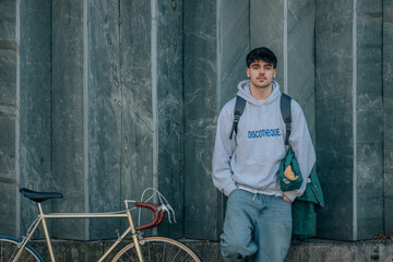 young man on street wall with vintage bicycle and copy-space