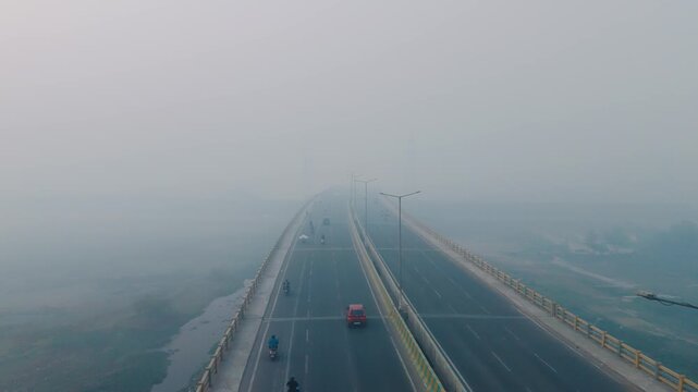 drone shot of highway covered in smog with very less visiblity, also difficult to breathe