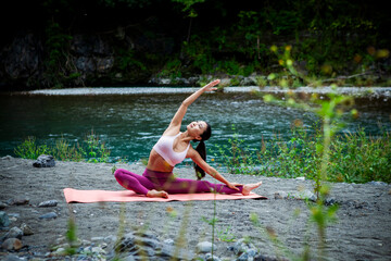 Young Japanese woman practicing side stretch yoga pose by a river, active outdoor wellness lifestyle with mindfulness, sustainability and mental wellbeing focus