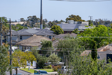 An elevated suburban view of residential rooftops and tree-lined streets in Tullamarine, Melbourne, showing detached houses in a neighborhood. Medium-density housing in Australia.