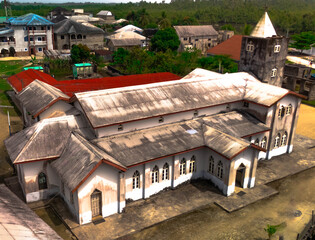 Aerial view of a church with red and grey roofs surrounded by buildings, capturing the essence of Soku Community, Abonnema, Port Harcourt, Nigeria.