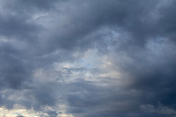 Fototapeta premium Dramatic storm clouds illuminated by soft sunset light in evening sky
