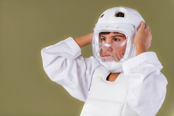 Boy adjusting protective helmet before karate session in studio. Shows fit control, readiness, and disciplined approach to training.
