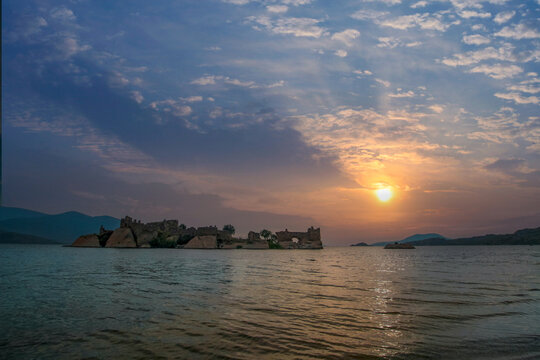 Different views of Bafa Lake in Aegean province of Turkey, boats pier island with monastery and rock forms on a colorful sunset and reflections