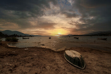 Different views of Bafa Lake in Aegean province of Turkey, boats pier island with monastery and rock forms on a colorful sunset and reflections