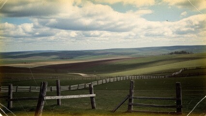 An open countryside landscape with green fields and a dramatic sky, conveying a sense of openness, calm, and natural beauty.
