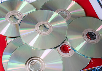 Stack of optical discs including CDs and DVDs. Data storage and digital media concept.
