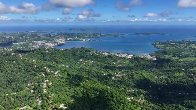 panning left across landscape around Bay of Robert (Baie du Robert), a large bay on the Atlantic east coast of Martinique with many small islets, to Fort-de-France on west coast, 4k aerial footage