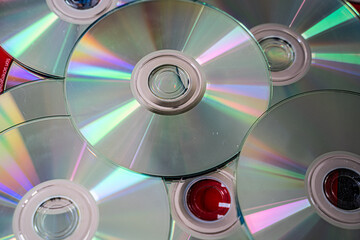 Shiny optical discs CDs and DVDs stacked together. Physical digital storage media concept.