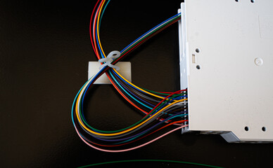 Colored electrical wires connected to an electronic device. Power supply and technology connection concept.