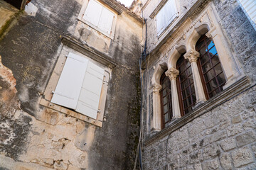 Stare zabytkowe kamienice i uliczki w mieście Trogir w Chorwacji z pięknymi oknami i okiennicami.  © Franciszek