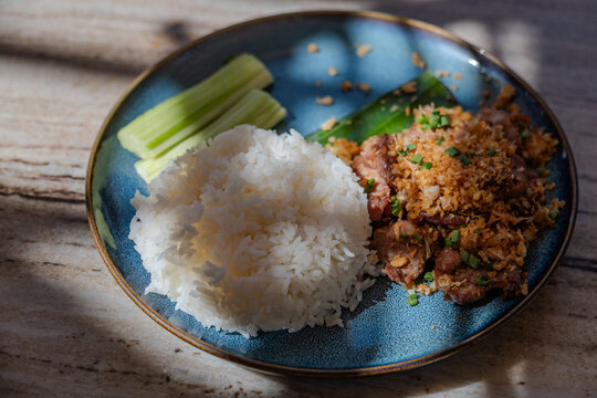 Thai's style main dish for lunch made from steamed rice serving with sliced pock stir fried with garlic