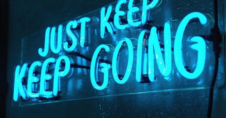 Bright neon sign displays motivational phrase. Dark background emphasizes glowing text, creating inspiring visual impact.