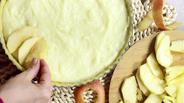 Woman preparing Apple Tart Pie Centered on Rustic Plaited Doily with Fresh Apple Slices and Cutlery