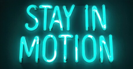 Fototapeta premium Bright turquoise neon sign displays text Stay In Motion against dark wall. Simple, modern aesthetic. Inspiring message.