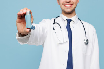 Close up young male doctor man wear white medical gown suit work in hospital clinic office hold give inhaler show respiratory care isolated on plain blue background studio Healthcare medicine concept