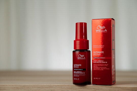STRASBOURG, FRANCE - DECEMBER 11, 2025 : A still life photograph of the Wella Ultimate repair hair leave-in bottle and box on a wooden surface.