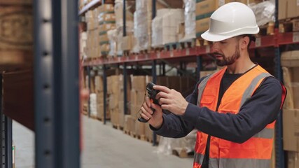 Warehouse worker scanning barcodes on packages with scanner