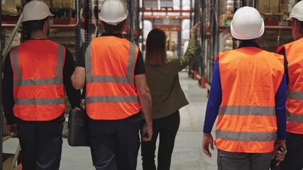 Female manager inspecting warehouse with industrial workers - Powered by Adobe