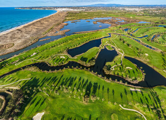 The Ultimate Retirement Dream: Cinematic Aerial Flyover of Salgados Golf Course Nestled Between the Atlantic Ocean and Natural Lagoons in Algarve, Portugal