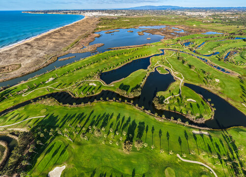 The Ultimate Retirement Dream: Cinematic Aerial Flyover of Salgados Golf Course Nestled Between the Atlantic Ocean and Natural Lagoons in Algarve, Portugal