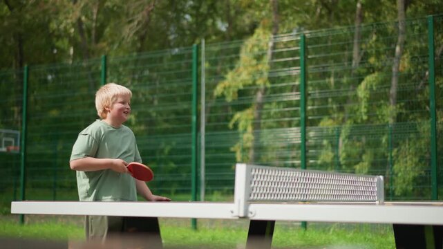 Casual Outdoor Ping Pong Coaching Session, Relaxed Park Setting With Woman Teaching Young Boy Table Tennis, Friendly Outdoor Environment Where Woman Instructs Boy In Table Tennis Techniques