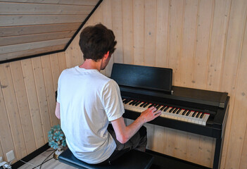 Man playing piano keyboard in cozy home interior