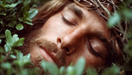 Close-up of Jesus Christ's face with a crown of thorns, surrounded by greenery.